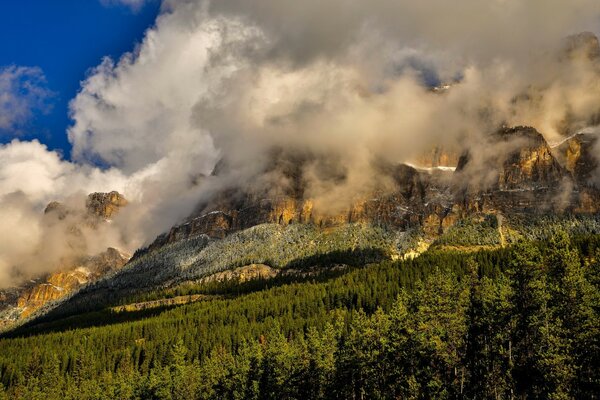 A landscape of the sky in clouds and a mountainous slope