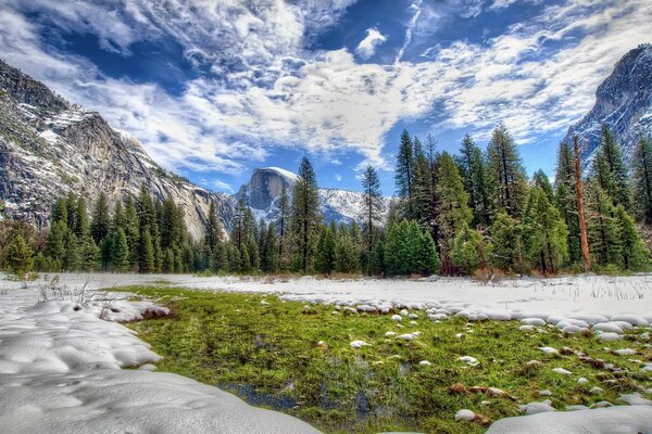 Der erste Schnee auf dem Grün in der Nähe der Berge in Amerika