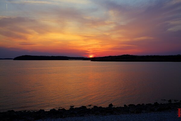 The calm of the sunset over the water. The sea in the twilight