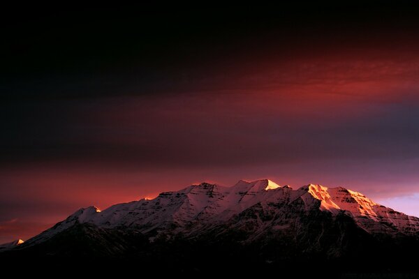 Rrzovo carmesí puesta de sol sobre las montañas