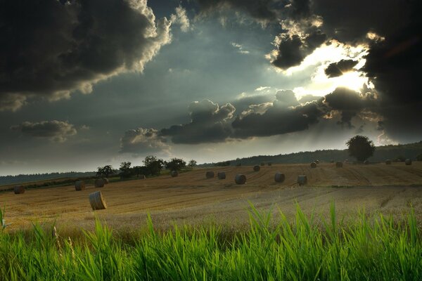 Hay in the field the evil sky as if before a thunderstorm