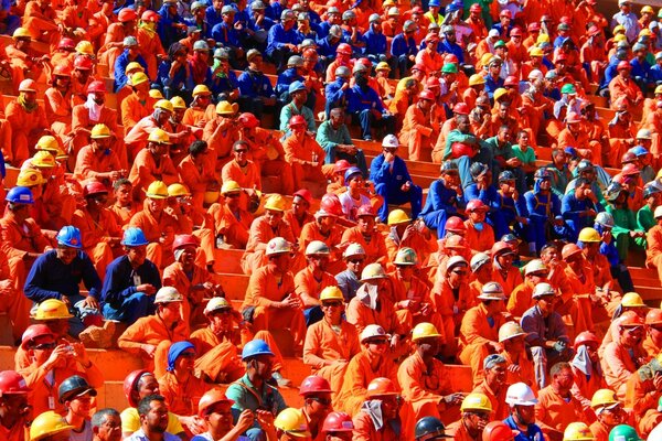 I lavoratori in uniforme multicolore dell indumento si siedono