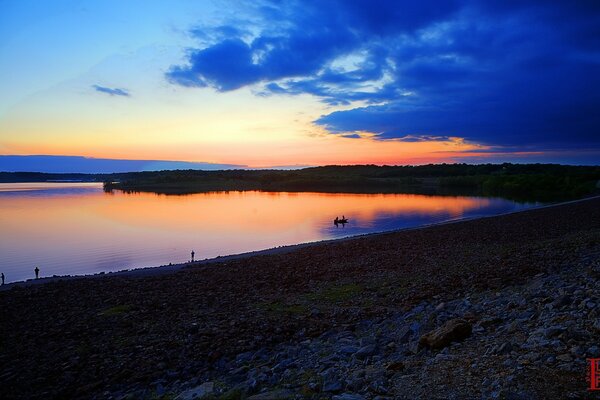 Sonnenuntergang am Fluss mit Blick auf Berge und Wolken