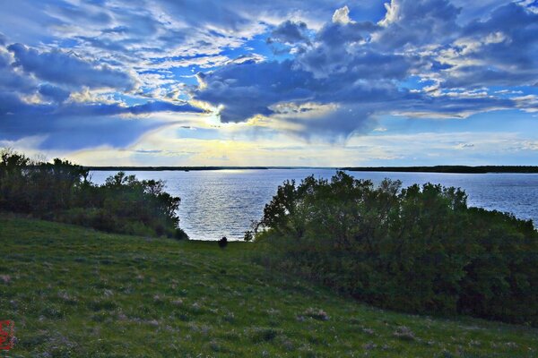 Sunset in the clouds over the lake view from the hill