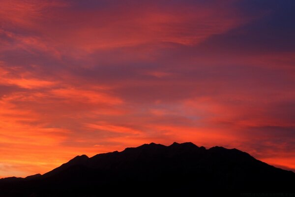 Erschreckender roter Sonnenuntergang in den Bergen