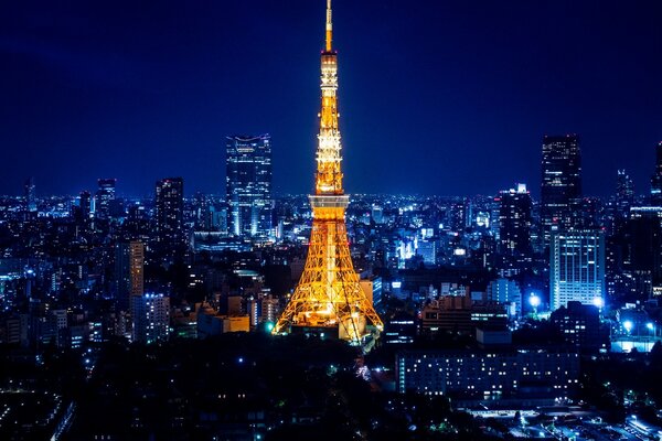 Torre iluminada y rascacielos en Asia