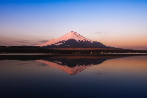 Una montaña con un pico nevado contra el fondo del agua