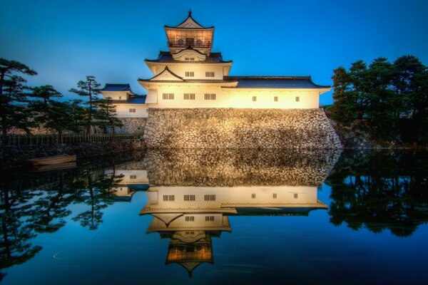 Gebäude im asiatischen Stil mit Nachtbeleuchtung auf Wasserhintergrund