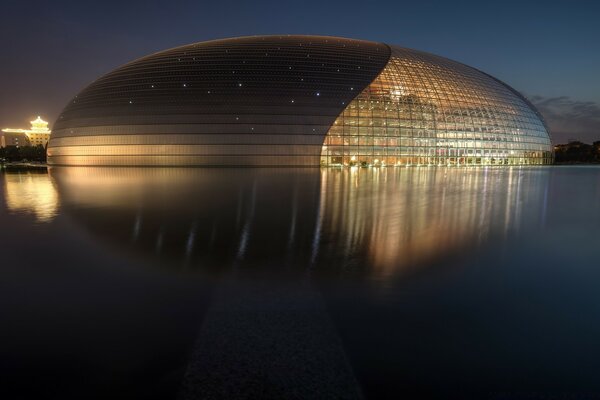 An unusual building with a reflection in the water