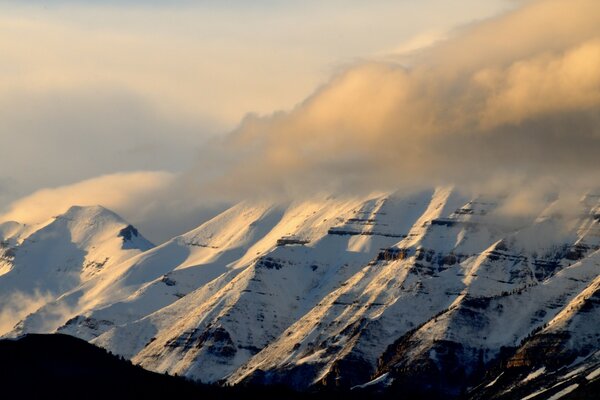 الجبال المغطاة بالثلوج مع الظلام والغيوم