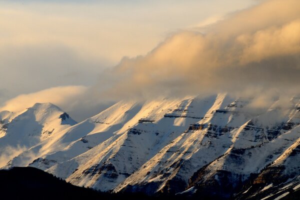 Montagnes enneigées avec l obscurité et les nuages