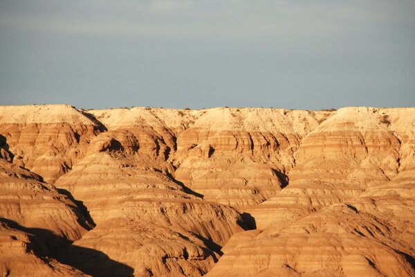 View of sandy mountains against a gray sky