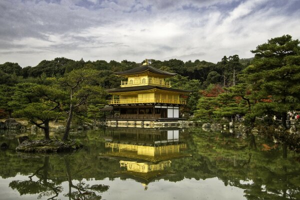 Pagoda by the river against a cloudy sky