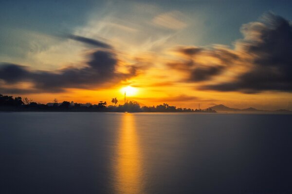 O pôr do sol é refletido nas águas da Ásia