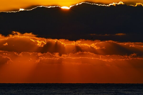 Sonnenaufgang über dem Meer in Asien hinter den Wolken