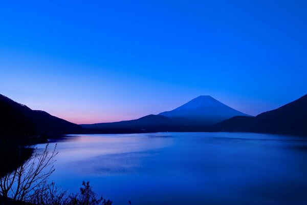 Puesta de sol de la tarde detrás de las montañas en el río