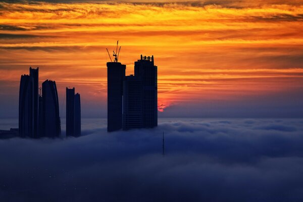 Silhouette of futuristic buildings against the background of a fiery sunset