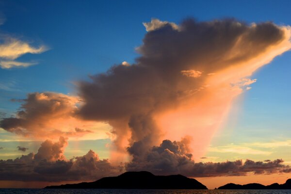 Puesta de sol sobre las montañas en el fondo del cielo nublado