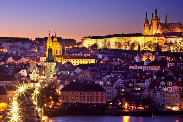 Una ciudad Europea iluminada por luces nocturnas bajo un cielo crepuscular