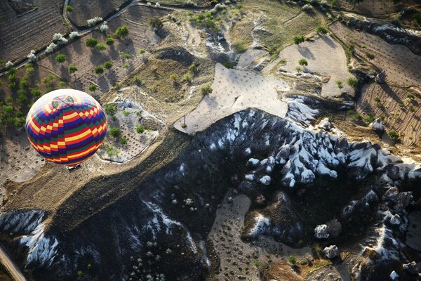 Ein heller Ballon fliegt über die Berge