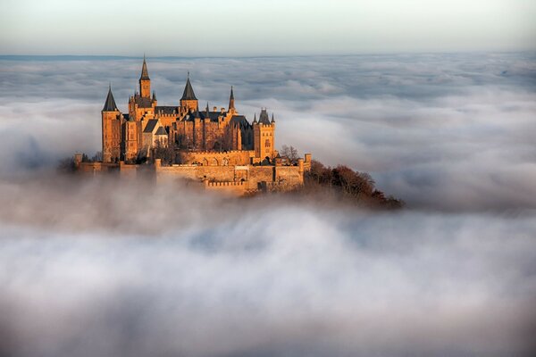 Eine riesige Burg auf einem Berg unter Nebel