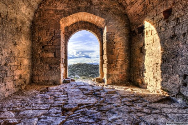 The window of an old building that overlooks the mountains