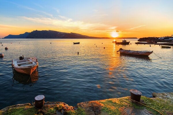 Mare con barche vicino alla riva al tramonto