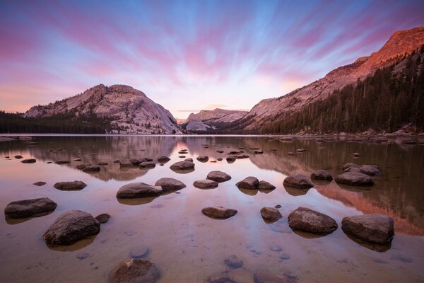 Sunset on the background of mountains water and forest