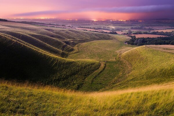 Paisaje puesta de sol en medio de campos verdes y montañas