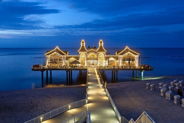 A house on stilts in the sea at night