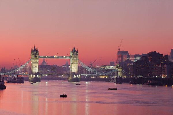 Puesta de sol rosa en el río y la ciudad