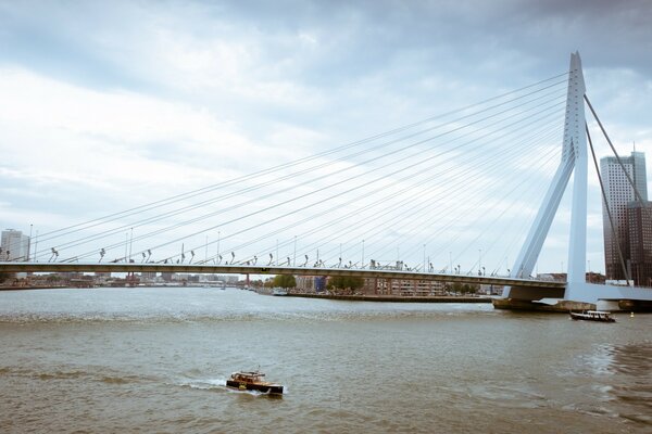 Hängebrücke über den Fluss auf bewölktem Himmel Hintergrund