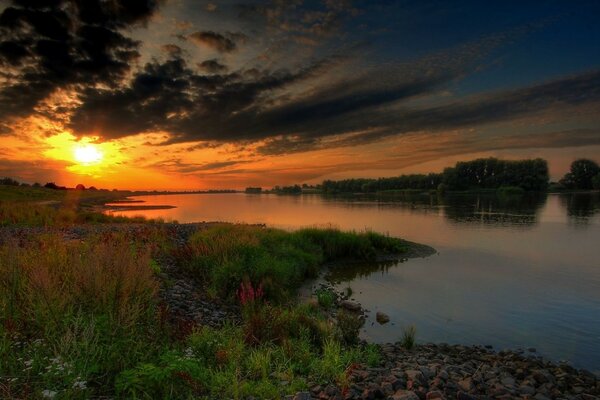 Feuriger Sonnenuntergang auf Flusshintergrund