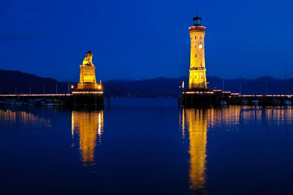 Faro en los reflejos del atardecer, aguas crepusculares