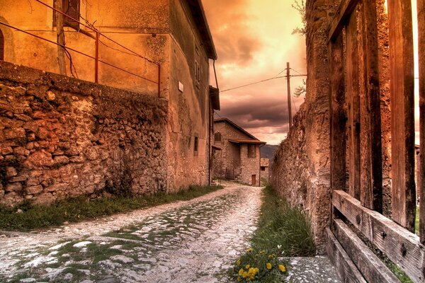 Vecchia strada acciottolata tra edifici rossi