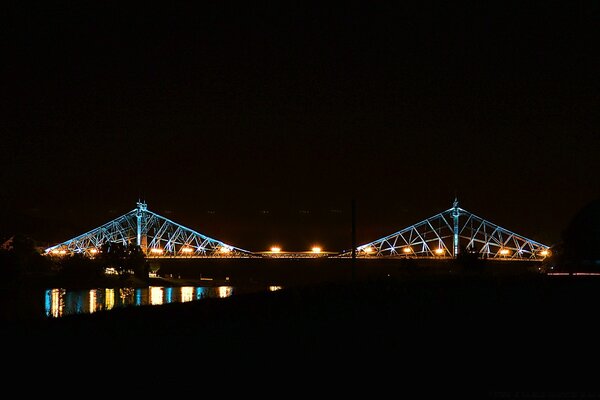 Das Licht der Brücke in der Nacht und ihr Glanz im Wasser