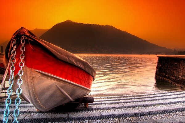 Beau bateau sur le rivage au coucher du soleil