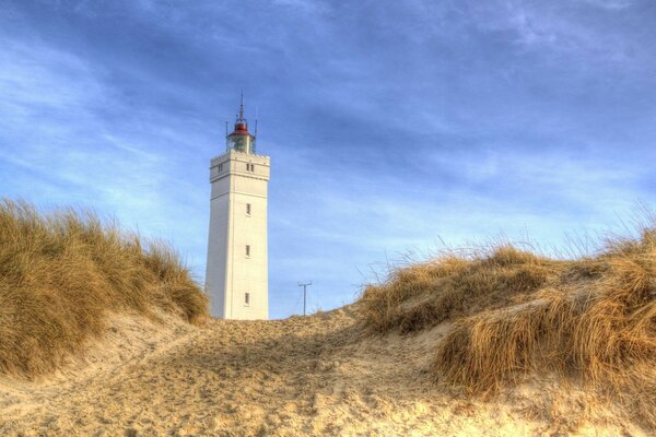 High lighthouse on the sandy shore