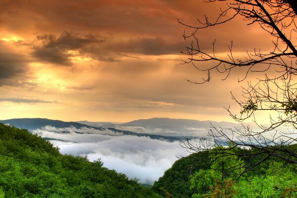 Amanecer sobre las montañas. Velo de nubes