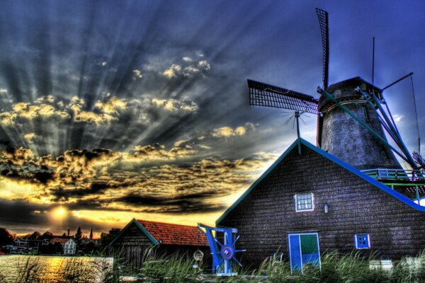 Casa e moinho de vento ao pôr do sol