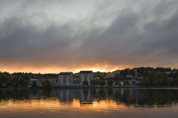 Sunset on the river under gloomy clouds