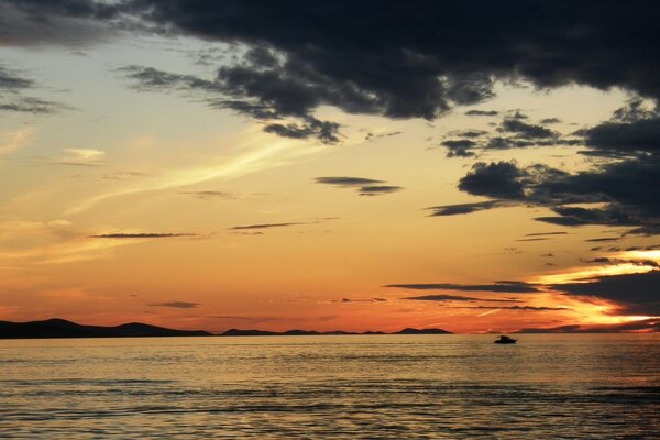 Cielo al atardecer con nubes sobre el agua