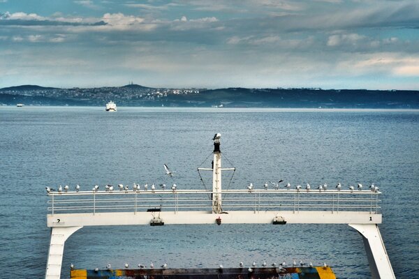 Foto del mar desde un barco con montañas en el fondo