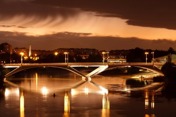 Bela vista da cidade europeia. Ponte iluminada sobre o rio