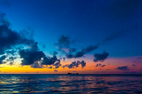 Die Sonne in den Wolken setzt sich über das Meer