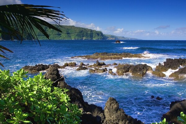 Rocks and an island in blue water