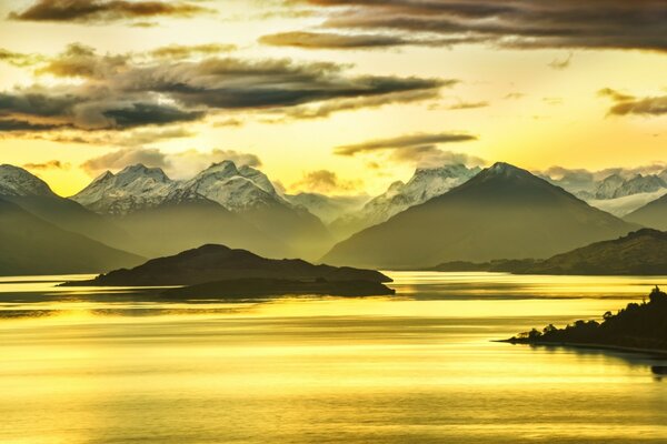 Hermoso amanecer cerca del agua y las montañas