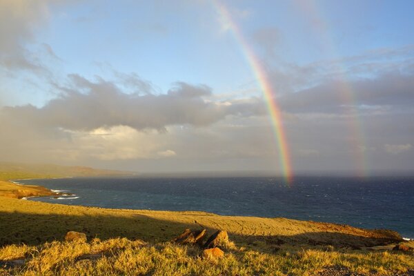 Zwei Regenbögen fallen ins Meer