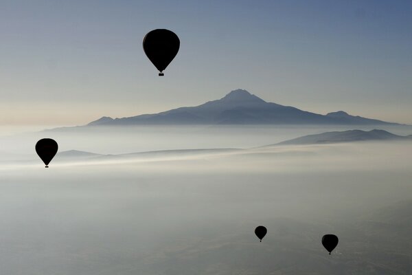 Luftballons am Himmel auf dem Hintergrund der Berge