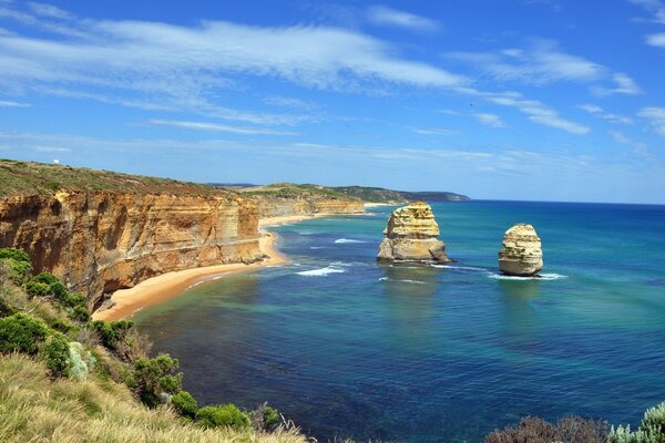 A sheer cliff covered with greenery above the sea